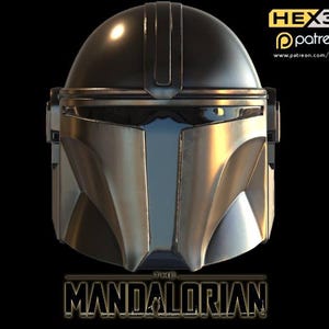 May include: A silver and black Mandalorian helmet with a dark visor. The helmet has a rounded top and angular features. The words "THE MANDALORIAN" are displayed in a gold, stylized font at the bottom of the image.