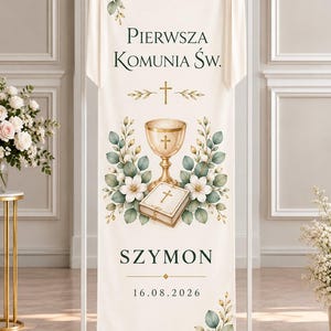 May include: A vertical cream-colored fabric banner featuring the text "PIERWSZA KOMUNIA ŚW.", a gold chalice, a white book with a cross, the name "SZYMON", and the date "16.08.2026". The banner is decorated with white flowers and green leaves.