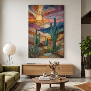 May include: A vertical wall art print featuring a desert landscape with tall green cacti in the foreground and rolling hills in the background. A large yellow sun sits at the top center, surrounded by radiating bands of orange, purple, and blue colors.