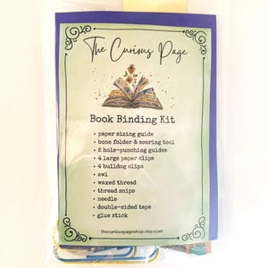 May include: A book binding kit from The Curious Page in a clear plastic package. The label lists contents: paper sizing guide, bone folder, scoring tool, 2 hole-punching guides, 4 large paper clips, 4 bulldog clips, awl, waxed thread, snips, needle, tape, and glue.