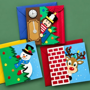 May include: Three square greeting cards with envelopes. One features a nutcracker by a grandfather clock, another a snowman decorating a tree, and the third a reindeer peeking from behind a brick chimney. Each card has colourful paper cutouts.