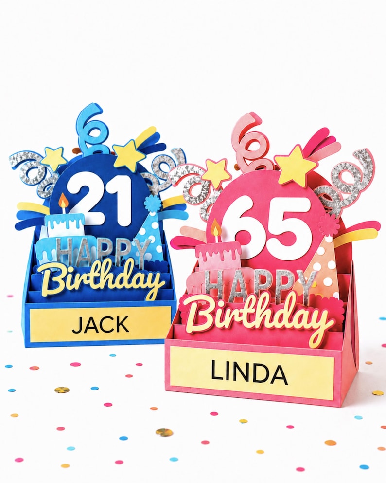 Two 3D layered paper birthday cards. The blue card features the number 21, a cake, and the name JACK. The pink card features the number 65, a cake, and the name LINDA. Both cards display the text HAPPY BIRTHDAY with silver accents.