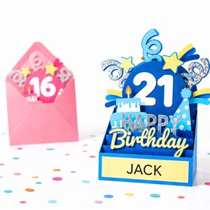 May include: A blue 3D pop-up birthday card featuring the number 21, a cake, a party hat, and the text "HAPPY Birthday" and "JACK" on a yellow base, with a pink envelope containing a card with the number 16 in the background.