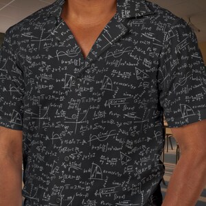 May include: A black short-sleeve button-down shirt featuring an all-over white print of various mathematical equations, geometric formulas, and scientific symbols including pi, summation signs, and trigonometric functions across the fabric.