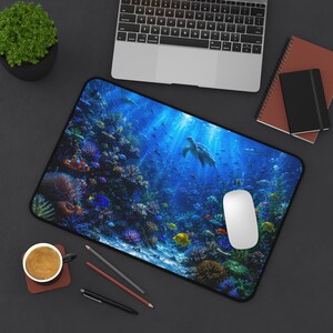 May include: A rectangular desk mat featuring a vibrant underwater scene with a sea turtle swimming through a coral reef filled with colorful tropical fish, including clownfish and yellow tangs, set against a deep blue ocean background.