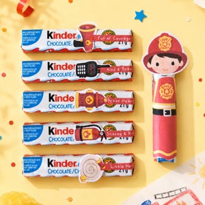Peut inclure: Cinq barres de chocolat Kinder avec des emballages sur le thème des pompiers illustrant un mégaphone, une radio, une borne, un extincteur et un tuyau, plus une barre verticale habillée en pompier avec casque et uniforme.