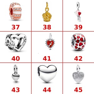 K&ouml;nnte beinhalten: Eine Sammlung von neun Schmuckanh&auml;ngern in Silber- und Goldt&ouml;nen mit verschiedenen Designs, darunter eine gestreifte Perle, eine Krone, herzf&ouml;rmige Anh&auml;nger und Anh&auml;nger mit roten Emaille-Akzenten, jeweils mit einer roten Zahl von 37 bis 45.
