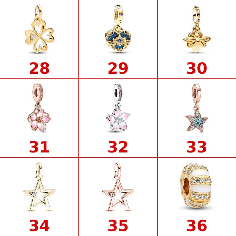 K&ouml;nnte beinhalten: Eine Sammlung von neun Schmuckanh&auml;ngern, nummeriert von 28 bis 36. Die Anh&auml;nger umfassen ein goldenes Kleeblatt, ein blaues Herz, eine goldene Biene, zwei rosa Blumenmotive, einen Seestern, zwei Sternumrisse und eine wei&szlig;-gold gestreifte Perle.