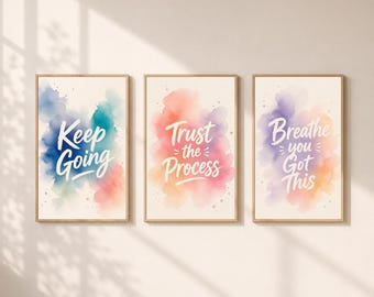May include: Three framed wall art prints with light wood frames. The first print features blue and teal watercolor splashes with the text Keep Going. The second has pink and orange watercolor with Trust the Process. The third has purple and orange with Breathe you Got This.