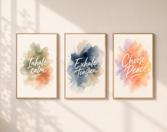 May include: A set of three framed wall art prints with light wood frames. Each print features a watercolor-style abstract background in muted tones and white cursive text. The prints read Inhale calm, Exhale tension, and Choose Peace respectively.