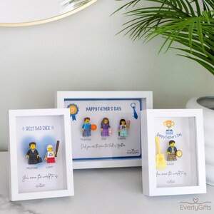 May include: Three white shadow box frames containing custom minifigures and printed text. The left frame says BEST DAD EVER, the center frame says HAPPY FATHER'S DAY, and the right frame says Happy Father's Day with the brand name EverlyGifts.