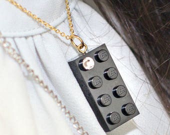 Brique LEGO® 2x4 noire avec un cristal SWAROVSKI® couleur 'diamant' sur une chaîne forçat plaquée argent/or ou sur une chaîne-boules noire