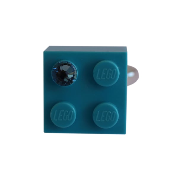 Brique LEGO® 2x2 bleu turquoise avec un cristal SWAROVSKI® bleu sur un support de bague plaqué argent/or réglable