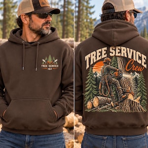 Op de afbeelding: Een donkerbruine hoodie met een kleine afbeelding op de borst met twee gekruiste kettingzagen en de tekst "TREE SERVICE". De achterkant toont een grote illustratie van een werker die een kettingzaag gebruikt in een boom met de tekst "TREE SERVICE Crew".