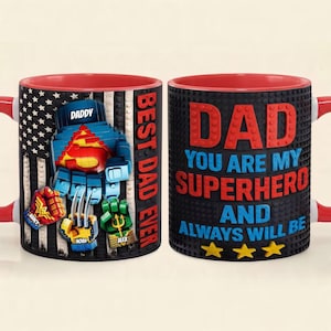 Puede incluir: Una taza de cerámica con un patrón de bandera estadounidense en blanco y negro y guanteletes de superhéroe tipo bloque etiquetados como Daddy, Nancy, Noah y Alex. El texto dice BEST DAD EVER y DAD YOU ARE MY SUPERHERO AND ALWAYS WILL BE en rojo y azul.