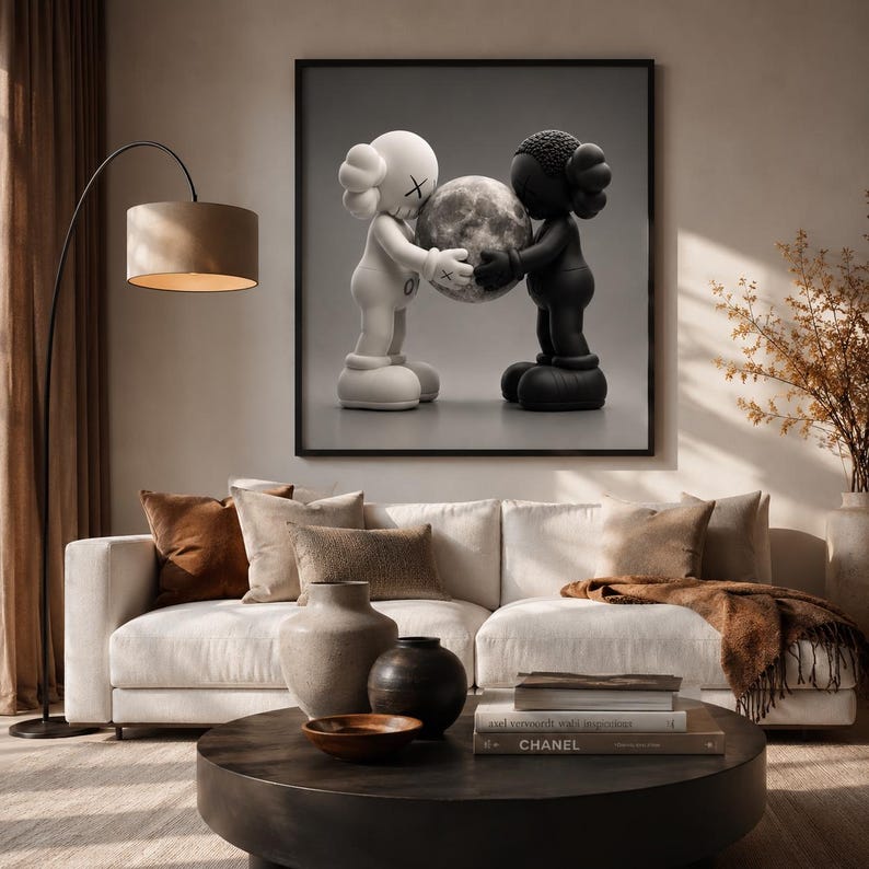 May include: A square wall art print featuring two cartoon-style figures, one white and one black, facing each other and holding a detailed, textured sphere resembling the moon between them. The figures have X-shaped eyes and rounded ears.