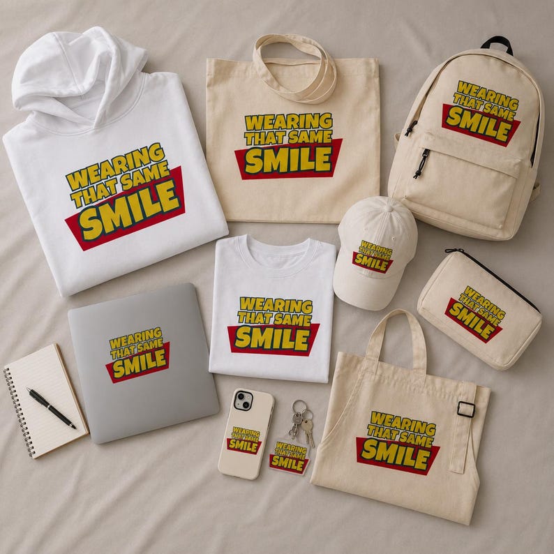 Peut inclure: Une collection d'articles blancs et beiges comprenant un sweat &agrave; capuche, un t-shirt, un sac fourre-tout, un sac &agrave; dos, une casquette, une trousse, un tablier, un autocollant pour ordinateur, une coque de t&eacute;l&eacute;phone et un porte-cl&eacute;s.
