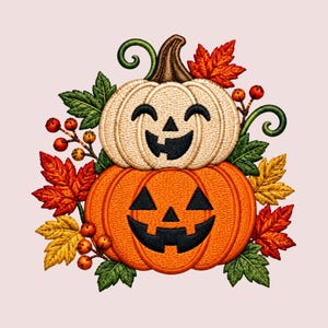Könnte beinhalten: Ein gesticktes Motiv mit zwei gestapelten Kürbissen mit geschnitzten Jack-o'-Lantern-Gesichtern. Der obere Kürbis ist cremefarben und lächelt, der untere ist orange mit einem gezackten Grinsen, umgeben von Herbstblättern und kleinen Beeren.