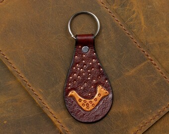 Leather keychain with a bird symbol
