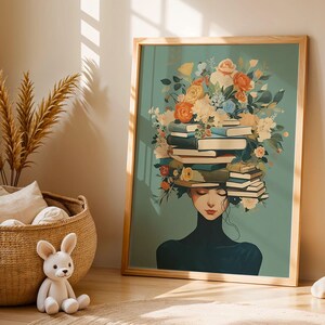Könnte beinhalten: Ein gerahmter Kunstdruck, der eine Person mit geschlossenen Augen zeigt, die einen Stapel Bücher auf dem Kopf trägt, umgeben von einem Blumenarrangement in Orange, Gelb und Blau vor einem salbeigrünen Hintergrund.