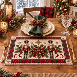 May include: A rectangular quilted placemat featuring two nutcracker figures, a central red bow, pine branches, and gold stars. The placemat has a cream-colored center with a red, green, and black plaid border. The design includes holly berries and pinecones.