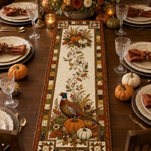 a beautifully set table with a centerpiece of a decorative runner that includes a pheasant, pumpkins, and other fall-themed elements. The table is set with plates, glasses, and other tableware, creating an inviting and festive atmosphere.