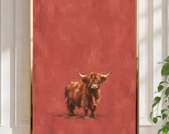 Peut inclure: Une impression d'art encadrée représentant une vache Highland brune aux longues cornes, debout sur un fond uni texturé de couleur terre cuite. L'œuvre est entourée d'un cadre fin en métal doré avec une bordure rectangulaire nette.