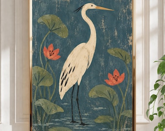 Peut inclure: Une impression d'art encadrée représentant un grand héron blanc debout dans une eau bleu foncé. La scène comprend des nénuphars verts et deux fleurs orange vif. L'œuvre présente une finition texturée et est dans un cadre doré fin.