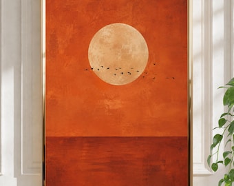May include: A framed wall art print featuring a large, pale circular moon centered against a textured, deep orange sky. A flock of small black birds is silhouetted in flight across the lower portion of the moon. The bottom third of the print depicts a dark, solid orange horizon line representing a calm body of water.