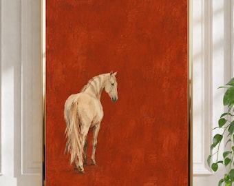 Peut inclure: Une impression d'art encadrée représentant un cheval de couleur crème claire debout sur un fond uni, texturé et orange brûlé profond. Le cheval est placé en bas à gauche, tourné vers la droite avec la tête tournée vers l'arrière.
