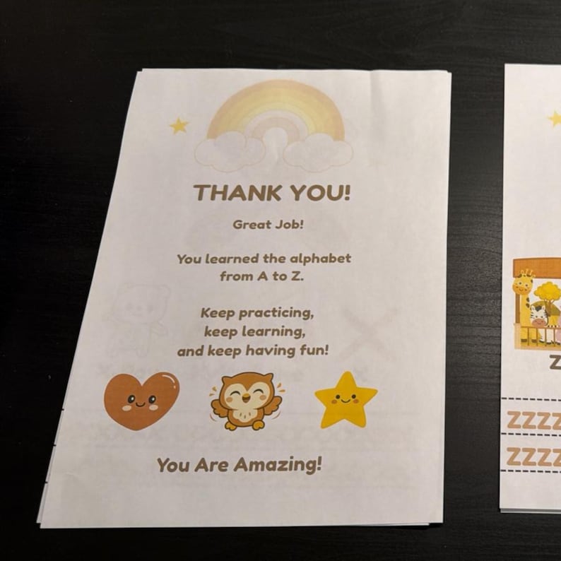 Op de afbeelding: Een wit papieren certificaat met een pastelkleurige regenboog en wolken bovenaan. De tekst luidt: THANK YOU! Great Job! You learned the alphabet from A to Z. Keep practicing, keep learning, and keep having fun! Bevat een hartje, een uil en een ster.