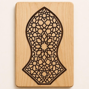 May include: A rectangular light-colored wooden plaque featuring a dark, laser-cut, intricate geometric pattern in the shape of a sandal. The design consists of interlocking stars and polygons, creating a symmetrical, open-work lattice motif.