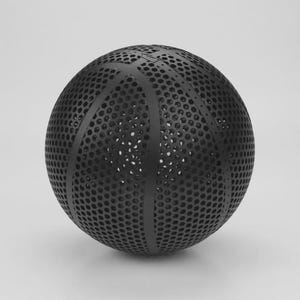 May include: A black basketball with a unique design. The ball features a series of small, evenly spaced holes across its surface, giving it a textured appearance. The classic basketball panel lines are visible.