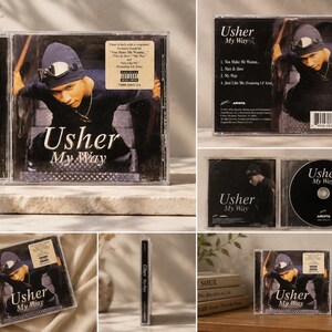 Puede incluir: Una colección de imágenes que muestran el CD "My Way" de Usher. La portada del álbum presenta a Usher con un atuendo negro y un gorro con gafas. La caja del CD es transparente y el título del álbum es visible.