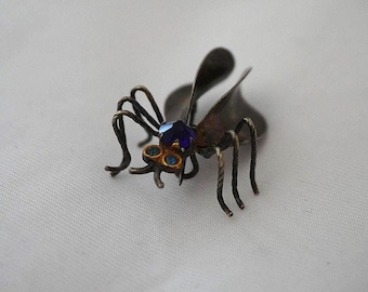Broche antiguo de plata con forma de insecto con ojos de colores.