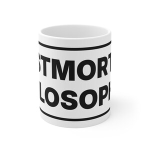 Peut inclure: Un mug en céramique blanche avec le texte noir en gras POSTMORTEM PHILOSOPHY, encadré par deux lignes horizontales noires en haut et en bas. Le mug présente une forme cylindrique avec une finition lisse et un design sobre et épuré.
