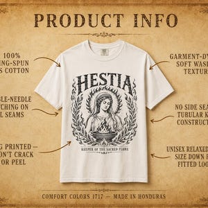 May include: Cream-colored t-shirt featuring a graphic of Hestia, the Greek goddess of the hearth, surrounded by a laurel wreath. The text "HESTIA" is above the image, with "KEEPER OF THE SACRED FLAME" below. The shirt is made of 100% ring-spun US cotton.