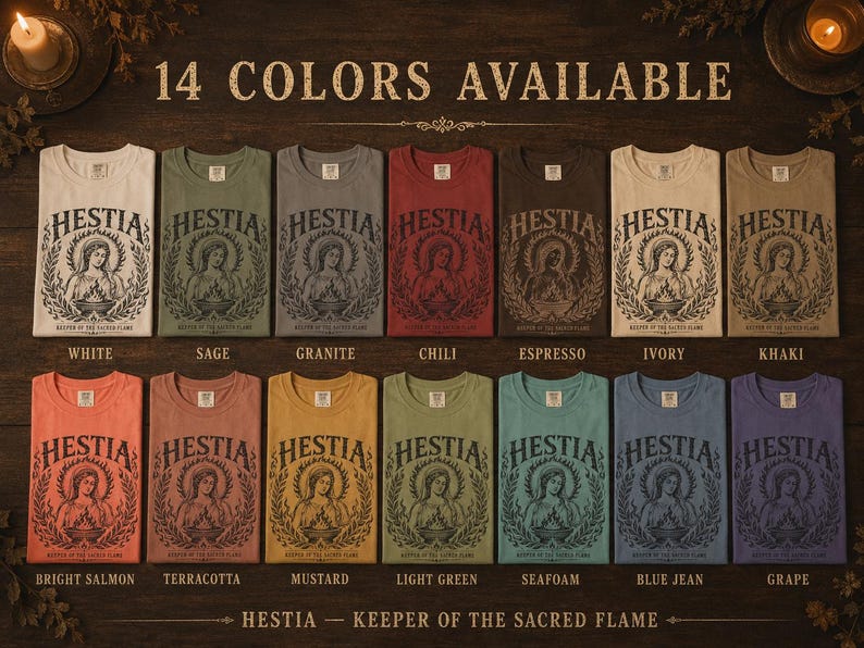 May include: A display of 14 different colored t-shirts, each featuring a graphic of a woman with a halo and the word "HESTIA". The shirts are labeled with colors like white, sage, and blue jean. Text at the bottom reads "HESTIA - KEEPER OF THE SACRED FLAME".