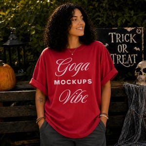 Könnte beinhalten: Ein rotes Kurzarm-T-Shirt mit dem weißen Schriftzug Goga MOCKUPS Vibe auf der Vorderseite. Das Shirt hat einen Rundhalsausschnitt und eine lockere Passform mit umgekrempelten Ärmeln, wobei das grafische Design mittig auf der Brust platziert ist.