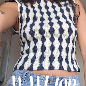 May include: A sleeveless crochet top featuring a repeating vertical pattern of navy blue and cream-colored wavy stripes. The garment has a high neckline and a straight hemline. The text WAVE top is printed in white across the lower portion of the image.