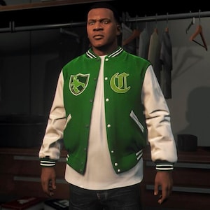 Può includere: Una giacca varsity verde e bianca indossata sopra una t-shirt bianca. La giacca presenta maniche bianche, un corpo verde, una toppa con la lettera C bianca sul petto e una toppa a forma di scudo verde con un grafico di scorpione.