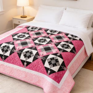 May include: A quilt featuring a geometric star pattern in shades of pink, black, white, and gray. The design consists of alternating star blocks and solid pink squares with a quilted texture, finished with a wide pink border and white trim.