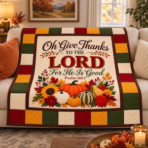 Può includere: Una trapunta rettangolare con un pannello centrale color crema con il testo Oh Give Thanks TO THE LORD For He Is Good Psalm 118:1, circondato da zucche, girasoli e foglie autunnali, con un bordo di quadrati alternati rossi, verdi e dorati.