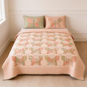 May include: A quilt and two matching pillow shams featuring a repeating patchwork butterfly pattern in shades of peach, sage green, and cream. The butterfly wings are constructed from various floral and geometric fabric squares with stitched details.