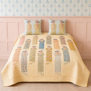 May include: A light yellow quilted bedspread featuring a repeating pattern of figures in long dresses with low-cut backs, accompanied by two matching square throw pillows. The figures are depicted in various floral and solid pastel color palettes.