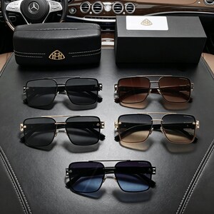 Peut inclure: Cinq paires de lunettes de soleil &agrave; monture carr&eacute;e avec doubles ponts et accents m&eacute;talliques dor&eacute;s. La collection comprend des verres aux teintes noir uni, d&eacute;grad&eacute; marron et d&eacute;grad&eacute; bleu, accompagn&eacute;s d'un &eacute;tui en cuir noir et d'une bo&icirc;te.