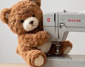 May include: A brown plush teddy bear with a cream-colored muzzle and paw pads positioned next to a light gray Singer sewing machine. The sewing machine features a red circular logo, a white dial, and a needle assembly near the bear's arm.