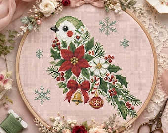May include: A circular wooden embroidery hoop containing a cross-stitch design of a bird decorated with poinsettias, holly, a red bow, a bell, and a Christmas ornament on pink fabric. The hoop is adorned with artificial flowers and a pink ribbon.