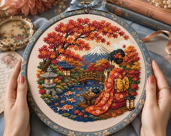 May include: A circular cross-stitch embroidery in a decorative frame featuring a person in a red patterned kimono sitting by a pond with koi fish, a stone lantern, a wooden bridge, and a snow-capped mountain under vibrant autumn maple trees.