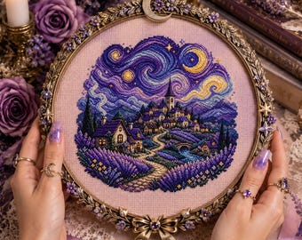 May include: A circular embroidery hoop featuring a cross-stitch design of a village at night under a swirling starry sky. The hoop has an ornate metallic frame decorated with small flowers, a crescent moon at the top, and a bow at the bottom.